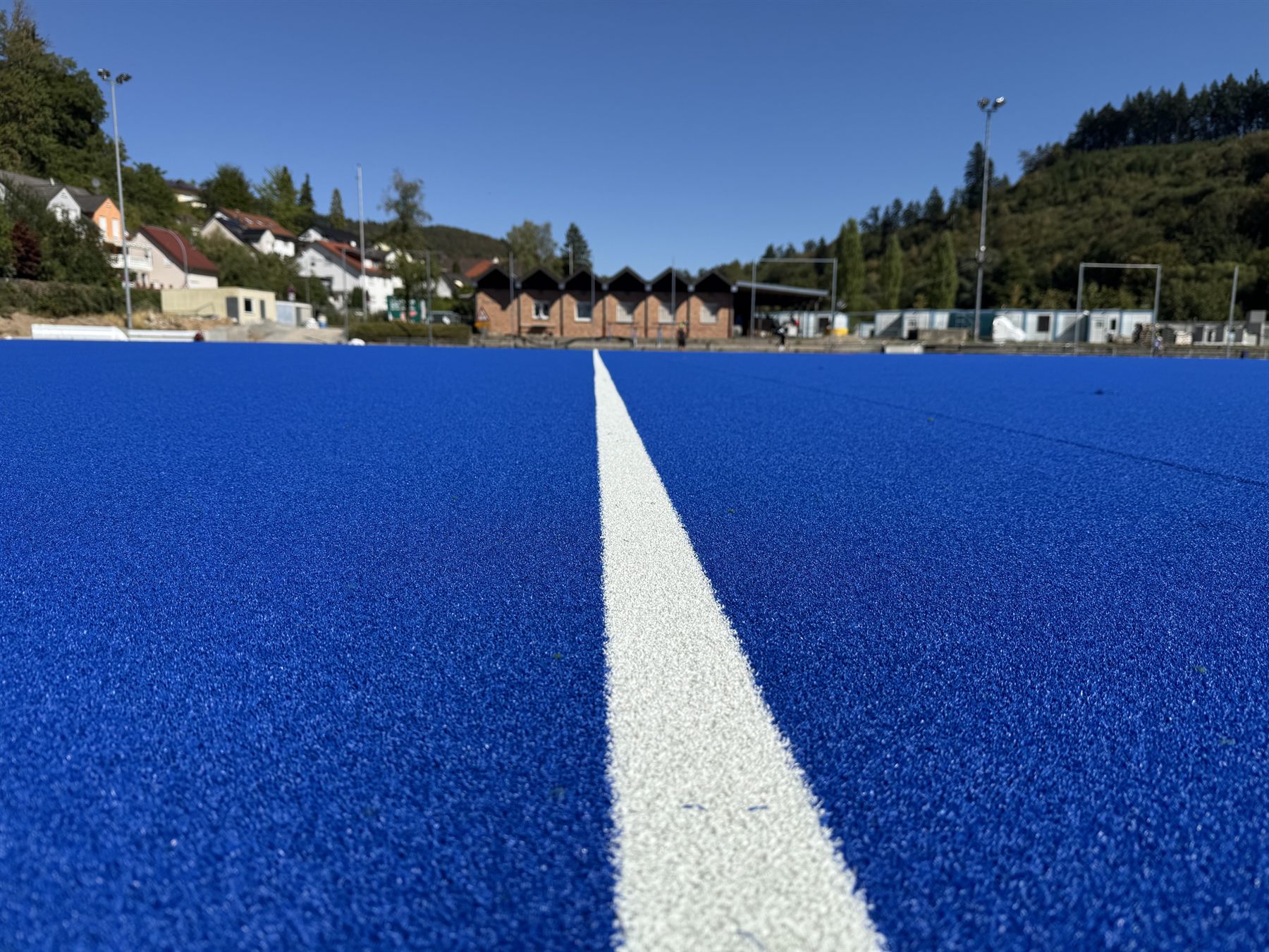 Blauer Hockey-Kunstrasen im Waldstadion Weinheim mit weißer Mittellinie